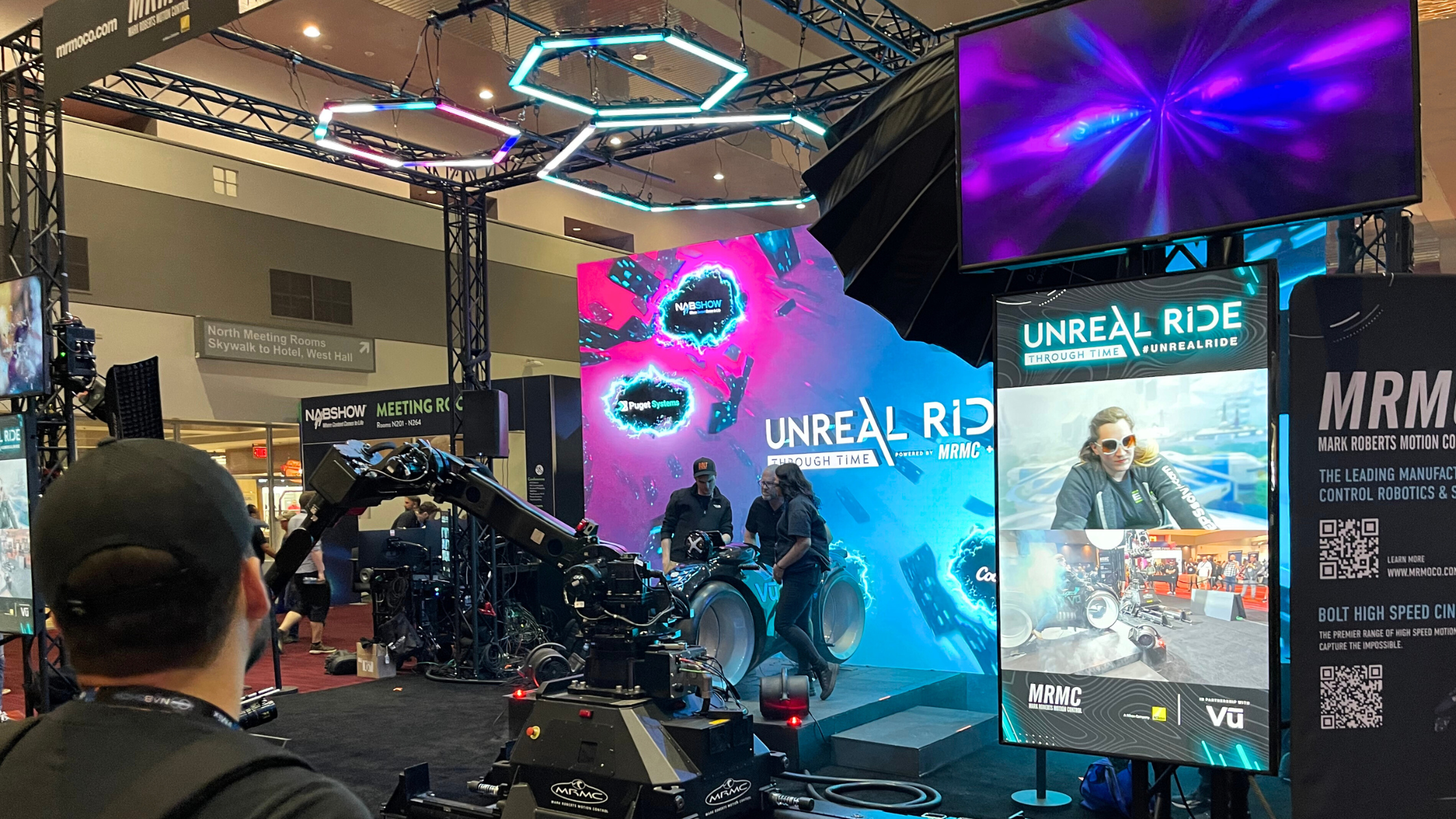 Image of people riding VR motorcycle on Unreal Ride stand at NAB 2023