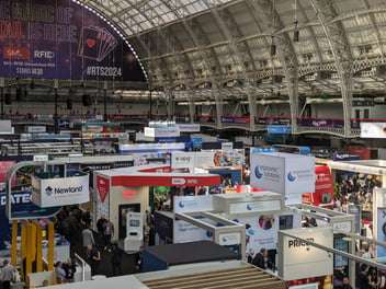 Image of Retail Tech Show 2024 in London at Olympia, with Victorian architecture surrounding multiple trade show booths